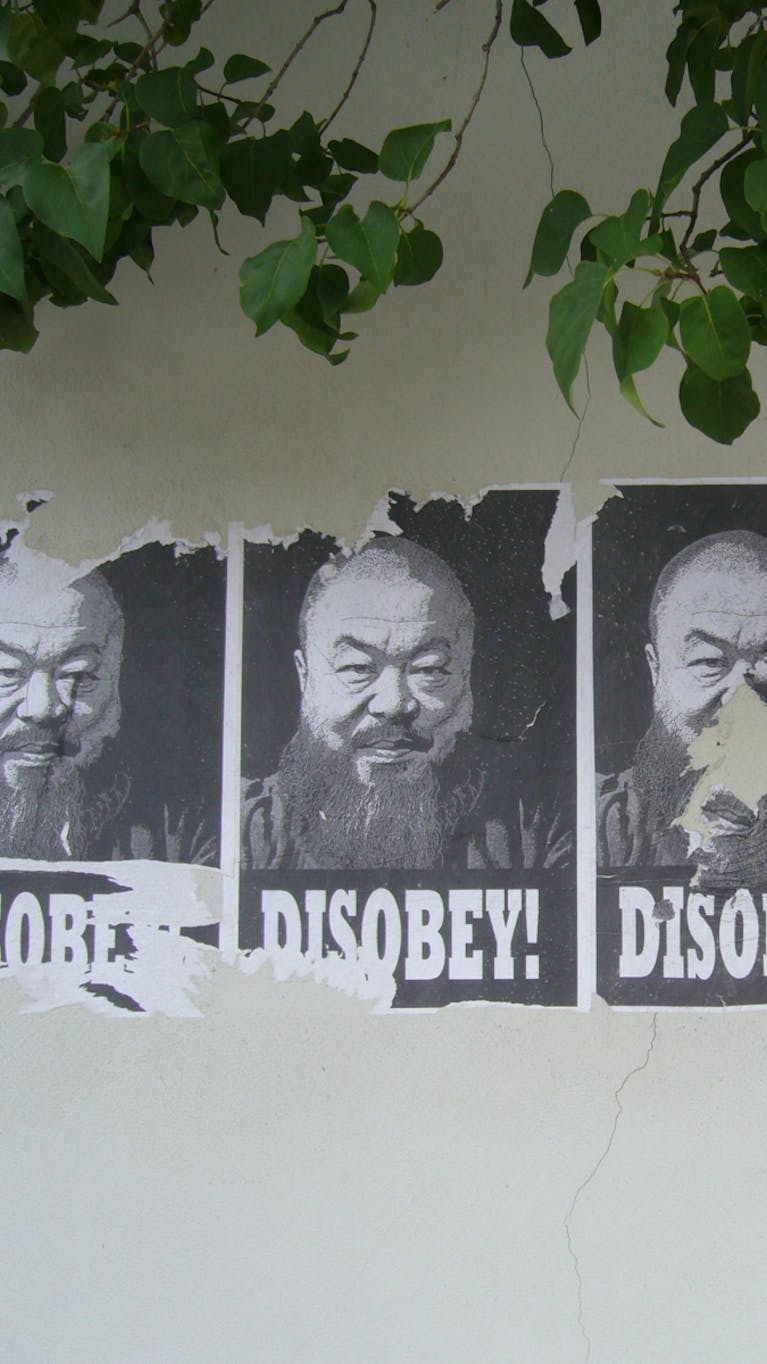Posters met een afbeelding van de Chinese kunstenaar Ai Wei Wei. De mensenrechten en de menselijke waardigheid zijn steeds meer onderwerp van literair werk, films, beeldende kunst en muziek – van ‘geëngageerde’ kunst.
