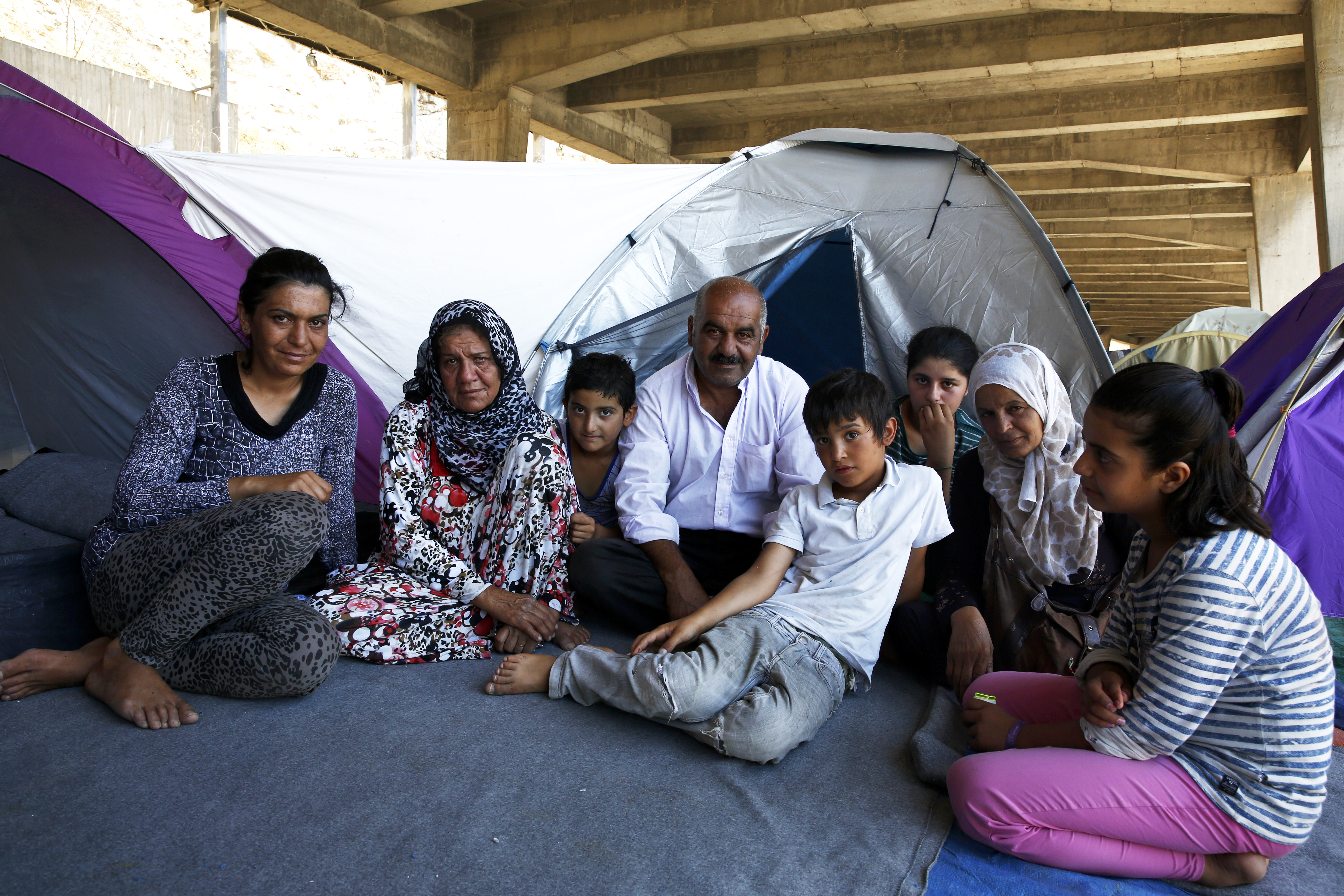 Koerdische familie uit Syrië in de haven van Piraeus, Griekeneland, in juli 2016, twee dagen nadat de Turkije-deal van kracht ging. Ze kunnen niet verder Europa in, maar ook niet terug naar Turkije, omdat sommigen van hen een chronische ziekte hebben.