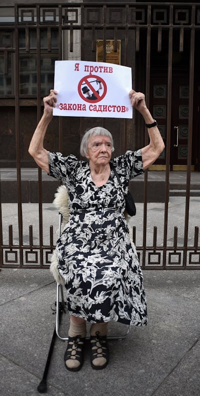 Moscow Helsinki Group president and member of the Kremlin's human rights council Lyudmila Alekseyeva holds a poster reading 