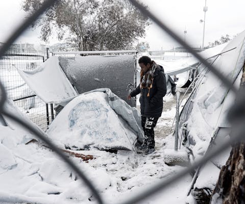 Een migrant staat naast in een tentenkamp op Lesbos, 7 januari 2016.