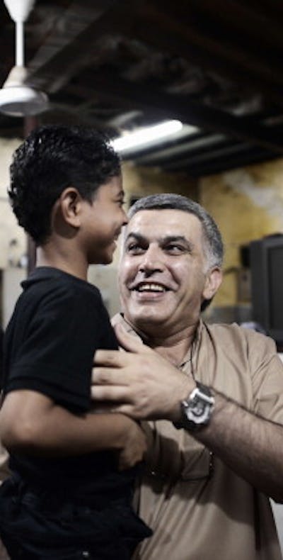 Bahraini human rights activist Nabil Rajab carries the son of Abdul Aziz al-Abbar, a Bahraini man who died from his wounds on February 23 after he was shot during clashes between police and protesters, on May 24, 2014 in the village of Sanabis, west of Manama. Rajab was recently released after 2 years in prison. AFP PHOTO/MOHAMMED AL-SHAIKH (Photo credit should read MOHAMMED AL-SHAIKH/AFP/Getty Images)