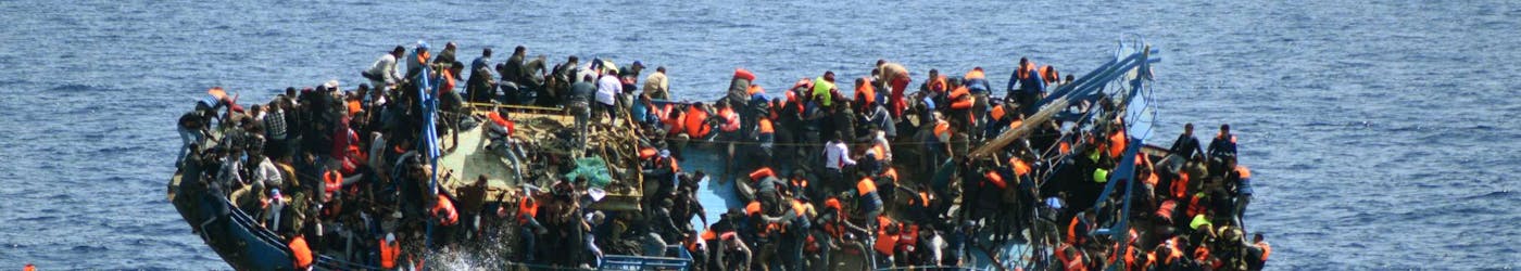 Migranten op een overvolle boot in de Middellandse Zee in mei 2016.