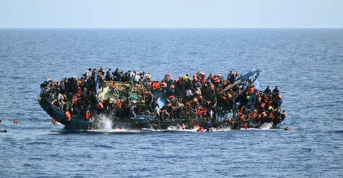 Migranten op een overvolle boot in de Middellandse Zee in mei 2016.