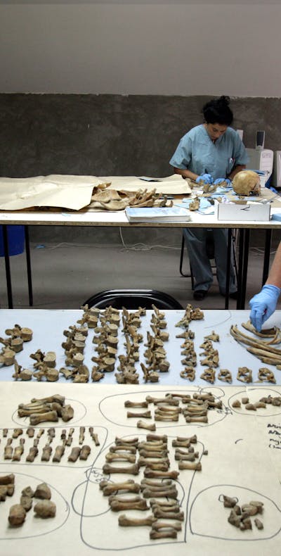 Forensisch antropologen onderzoeken botten uit massagraven bij Srebrenica (2005).