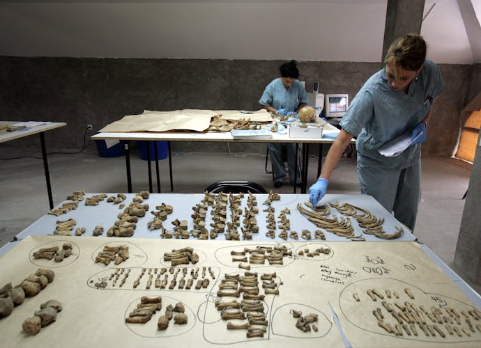 Forensisch antropologen onderzoeken botten uit massagraven bij Srebrenica (2005).