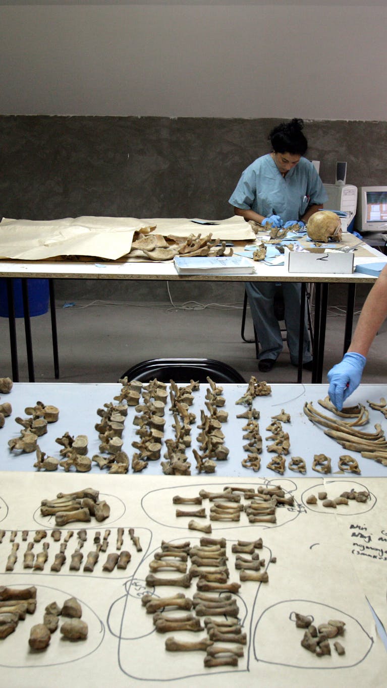 Forensisch antropologen onderzoeken botten uit massagraven bij Srebrenica (2005).