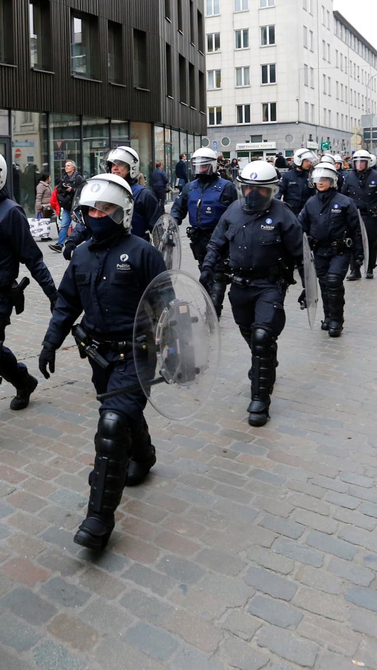 Belgische oproerpolitie door de straten van de Brusselse wijk Molenbeek, april 2016.