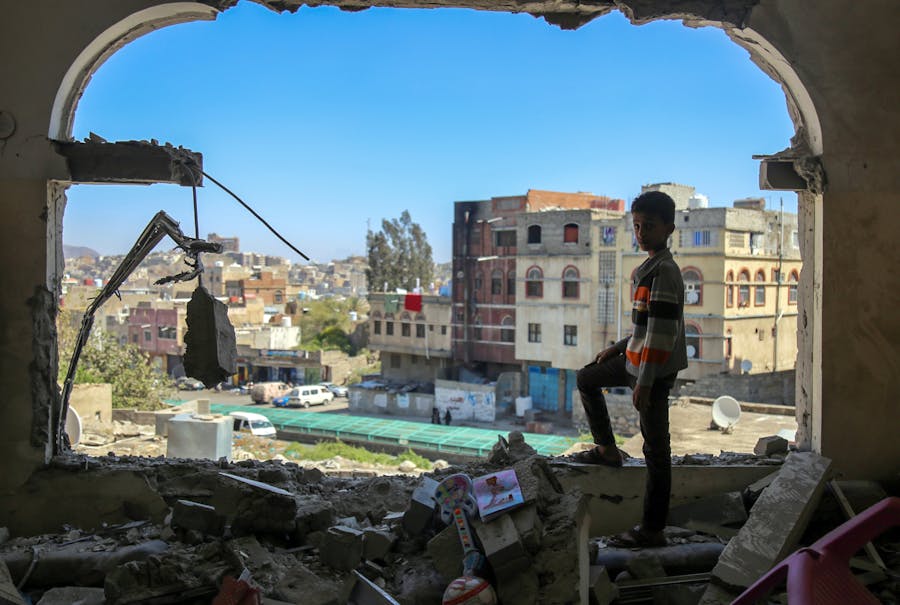 Een jongen uit de Jemenitische stad Taez kijkt uit over de verwoeste gebouwen, 3 februari 2016.