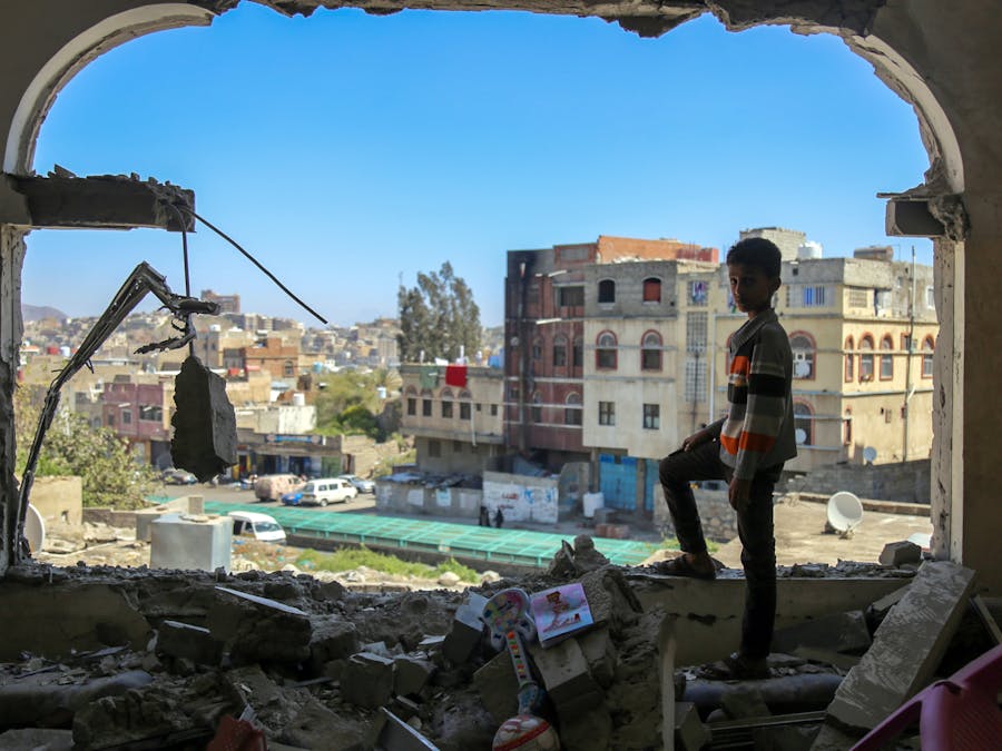 Een jongen uit de Jemenitische stad Taez staat in een gebouw dat gedeeltelijk verwoest is door een mortieraanval (3 februari 2016). Een coalitie onder aanvoering van Saudi-Arabië voert daar een oorlog tegen de Houthi's.