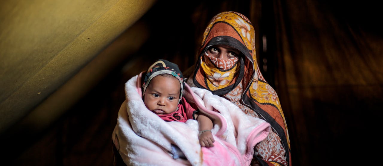 20 februari 2016: Um Abdulrahman draagt haar zoon van 10 maanden. Zij moesten vluchten toen hun huis geraakt werd door luchtaanvallen in de provincie Sada, grondgebied van de Huthi-milities. Ze leven nu in een vluchtelingenkamp in de nabijgelegen provincie Amran.