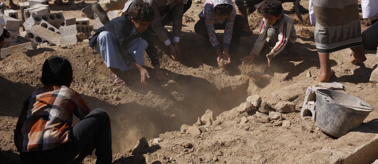 Kinderen gooien aarde op het zojuist gegraven graf van de journalist Al-Mjdad al-Mojali. Hij stierf aan verwondingen door granaatscherven die rondvlogen bij een luchtaanval door de door Saudi-Arabië geleide coalitie, in het noorden van Sanaa op 17 januari 2016. Op het moment dat hij overleed, deed hij onderzoek naar een andere luchtaanval waarbij 22 burgers waren gedood.