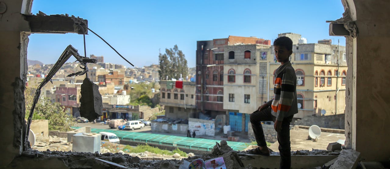 Een jongen bekijkt de schade van een mortierinslag in de zuidelijke stad Taiz, 3 februari 2016.