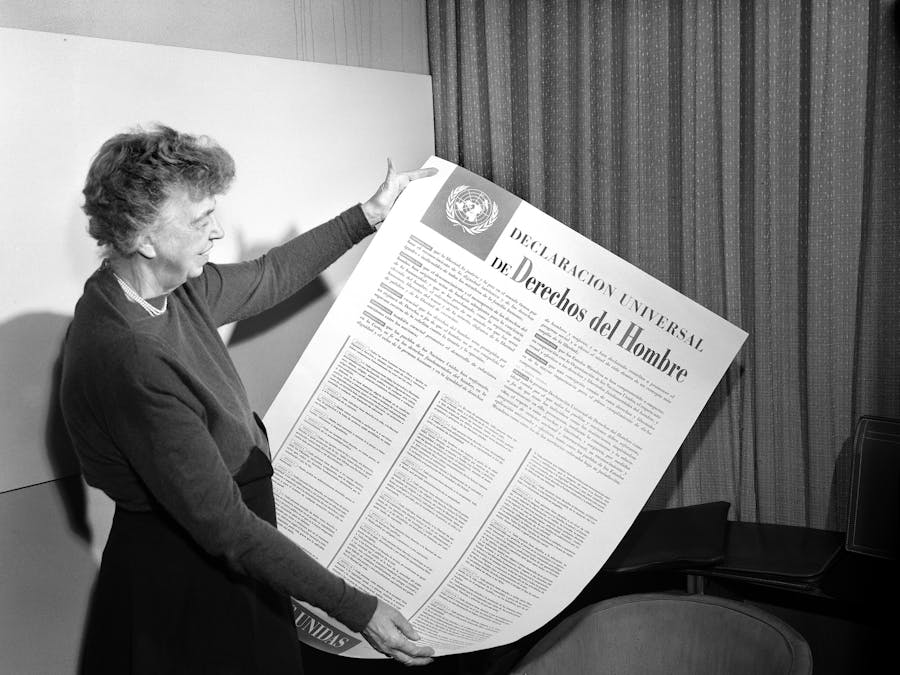 Eleanor Roosevelt bekijkt een poster met daarop de UVRM in het Spaans