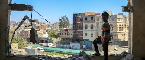 Een jongen bekijkt de schade na een mortieraanval op de Jemenitische stad Taiz in februari 2016. Alle partijen in het conflict, waaronder een door Saudi-Arabië geleide coalitie, hebben zich schuldig gemaakt aan ernstige schendingen van internationale humanitaire wetten.