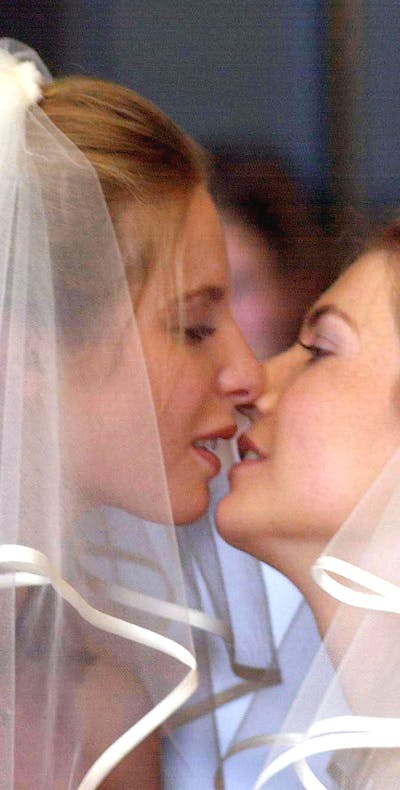 Twee bruiden kussen elkaar tijdens hun huwelijksceremonie eind april 2001 in Den Haag. Op 1 april 2001 werd in ons land het burgerlijk huwelijk opengesteld voor huwelijkspartners van hetzelfde geslacht. Nederland was daarmee het eerste land waar mensen van gelijke sekse konden trouwen. Foto: Jacques Zorgman / Newsmakers / Getty Images
