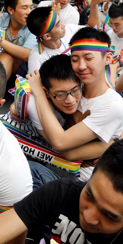 Demonstranten in Taiwan omhelzen elkaar nadat bekend werd gemaakt dat het constitutioneel hof besloot dat mensen van dezelfde sekse met elkaar mogen trouwen