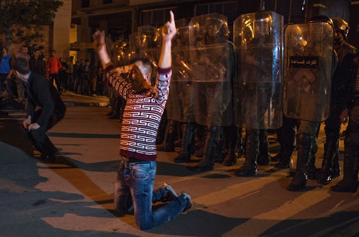 Demonstrators kneel before Moroccan police during a demonstration against corruption, repression and unemployment in the northern city of al-Hoceima on May 27, 2017. adel Senna/AFP/Getty Images