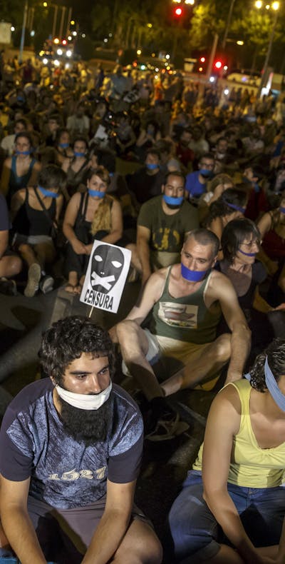 Demonstranten hebben hun mond afgeplakt tijdens een protestactie tegen een nieuwe veiligheidswet in Madrid in juli 2015.