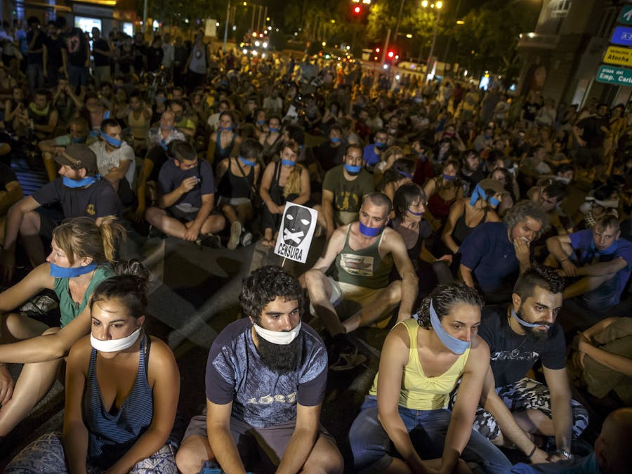 Demonstranten hebben hun mond afgeplakt tijdens een protestactie tegen een nieuwe veiligheidswet in Madrid in juli 2015.