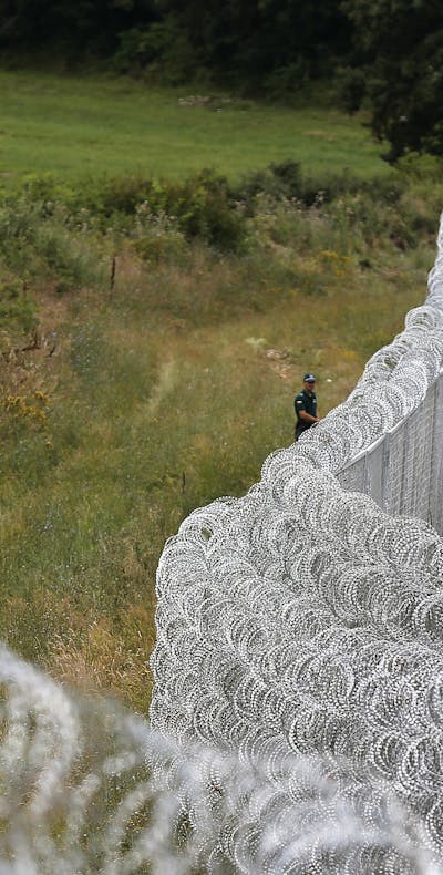Bulgaarse oproerpolitie bij een prikkeldraadhek aan de Bulgaars-Turkse grens (2014). De Bulgaren bouwden het hek in een reactie op het stijgende aantal asielzoekers en vluchtelingen, die voornamelijk uit Syrië afkomstig waren.