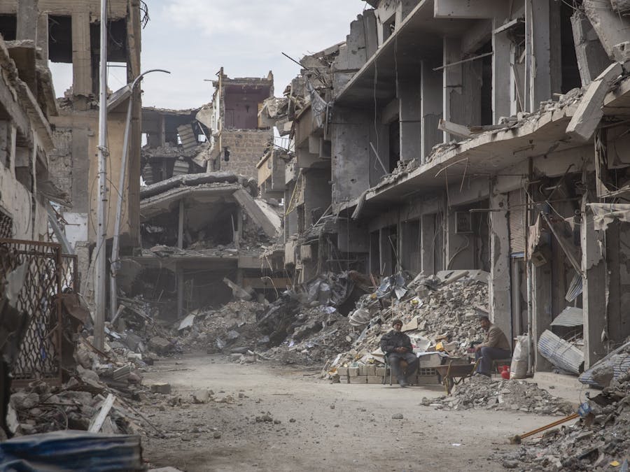 Twee inwoners van Raqqa tussen de puinhopen in hun verwoeste stad, februari 2018