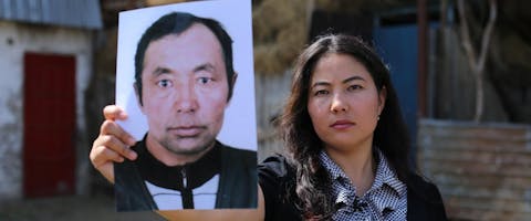 Bota Kussaiyn met een foto van haar vader die in een 'heropvoedingskamp'in China zit