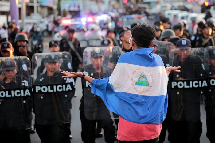 Een demonstrant tegen het bewind van president Daniel Ortega staat op 13 september 2018 tegenover de oproerpolitie in Managua, de hoofdstad van Nicaragua.