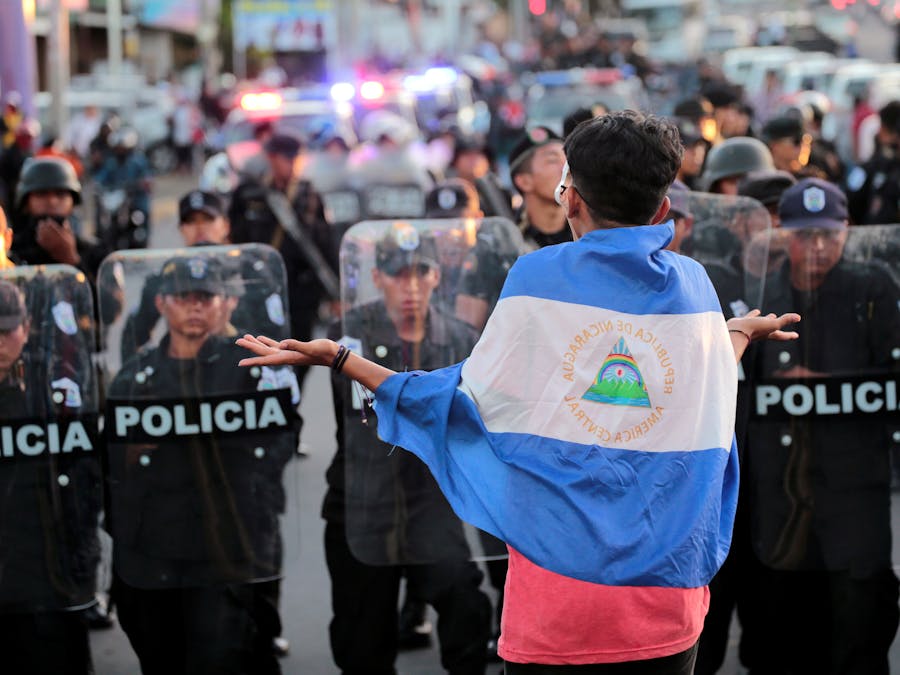 Een demonstrant tegen het bewind van president Daniel Ortega staat op 13 september 2018 tegenover de oproerpolitie in Managua, de hoofdstad van Nicaragua.
