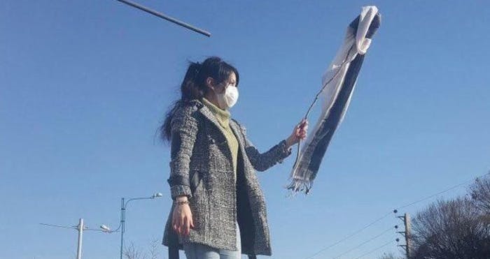 Een vrouw in de stad Karaj in Iran demonstreert tegen de hijab-wetten.