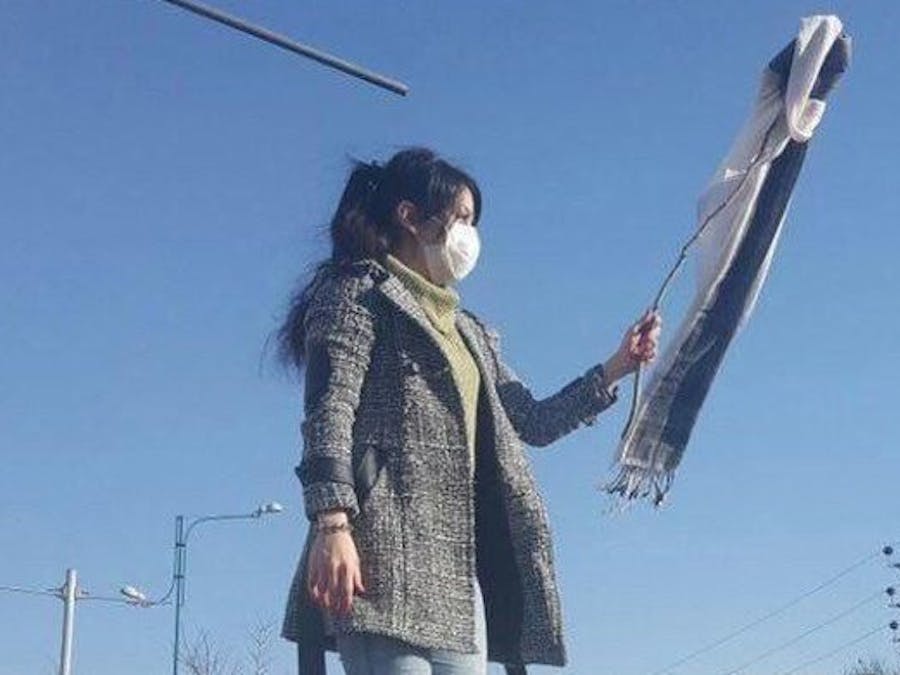 Een vrouw in de stad Karaj in Iran demonstreert tegen de hijab-wetten.