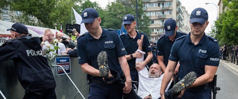 De Poolse politie voert een man af die deelnam aan een protest tegen de plannen van de regering om politieke benoemingen van rechters mogelijk te maken De Poolse politie voert een man af die deelnam aan een protest tegen de plannen van de regering om politieke benoemingen van rechters mogelijk te maken