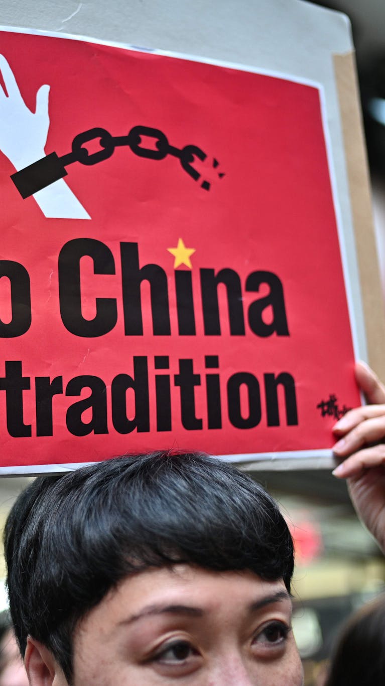 Een demonstrant houdt een bord omhoog uit protest tegen de plannen voor een nieuwe uitleveringswet in Hongkong