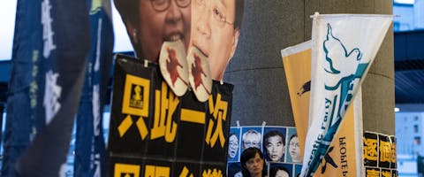 Een demonstrant staat voor een poster met een foto van de leider van Hongkong, Carrie Lam, tijdens een protest tegen de nieuwe uitleveringswet in Hongkong