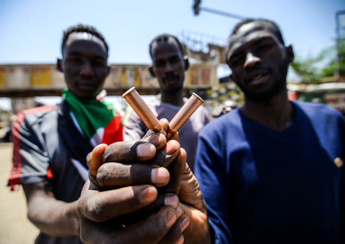 Een man toont de hulzen van kogels waarmee veiligheidstroepen in Sudan op vreedzame demonstranten schoten