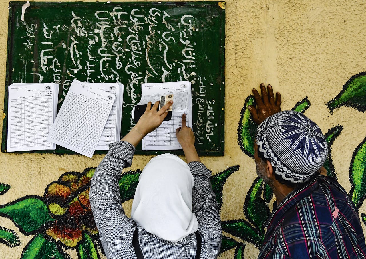 Egyptenaren zoeken hun naam op de lijst om te kunnen stemmen tijdens het referendum afgelopen april