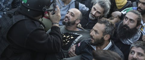 Een demonstrant en een agent van de oproerpolitie ontmoeten elkaar tijdens een demonstratie waarin de regering beschuldigd wordt van corruptie en een economisch wanbeleid, 4 november 2019..