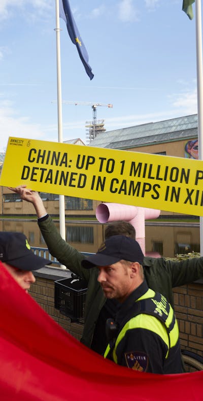 Een activist van Amnesty demonstreert tijdens het bezoek van de Chinese premier Li Keqiang aan het Gemeentemuseum in Den Haag tegen de massale opsluiting van Oeigoeren in ‘heropvoedingskampen’ in de Chinese provincie Xinjiang.
