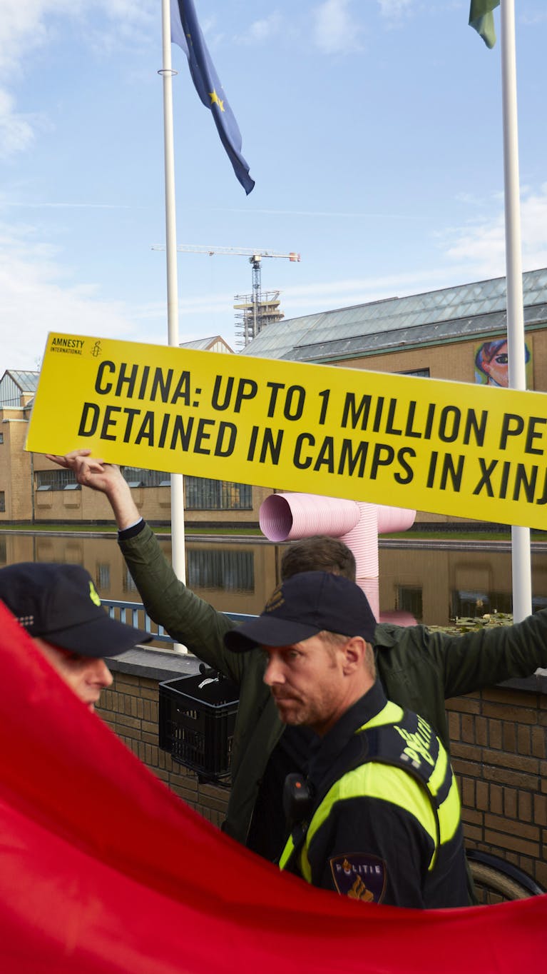 Een activist van Amnesty demonstreert tijdens het bezoek van de Chinese premier Li Keqiang aan het Gemeentemuseum in Den Haag tegen de massale opsluiting van Oeigoeren in ‘heropvoedingskampen’ in de Chinese provincie Xinjiang.