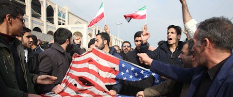 Iraniërs verscheuren een Amerikaanse vlag tijdens een demonstratie in Teheran. Zo protesteren zij tegen het doden van generaal Qasem Soleimani van de Iraanse Revolutionaire Garde op 3 januari 2020. Hij werd gedood tijdens een Amerikaanse droneaanval op het vliegveld in de Iraakse hoofdstad Bagdad. © Atta Kenare/AFP via Getty Images