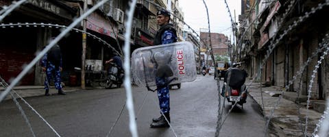 Agenten bij een wegblokkade in Jammu nadat de Indiase regering de autonomie van Jannu en Kashmir heeft ingetrokken.