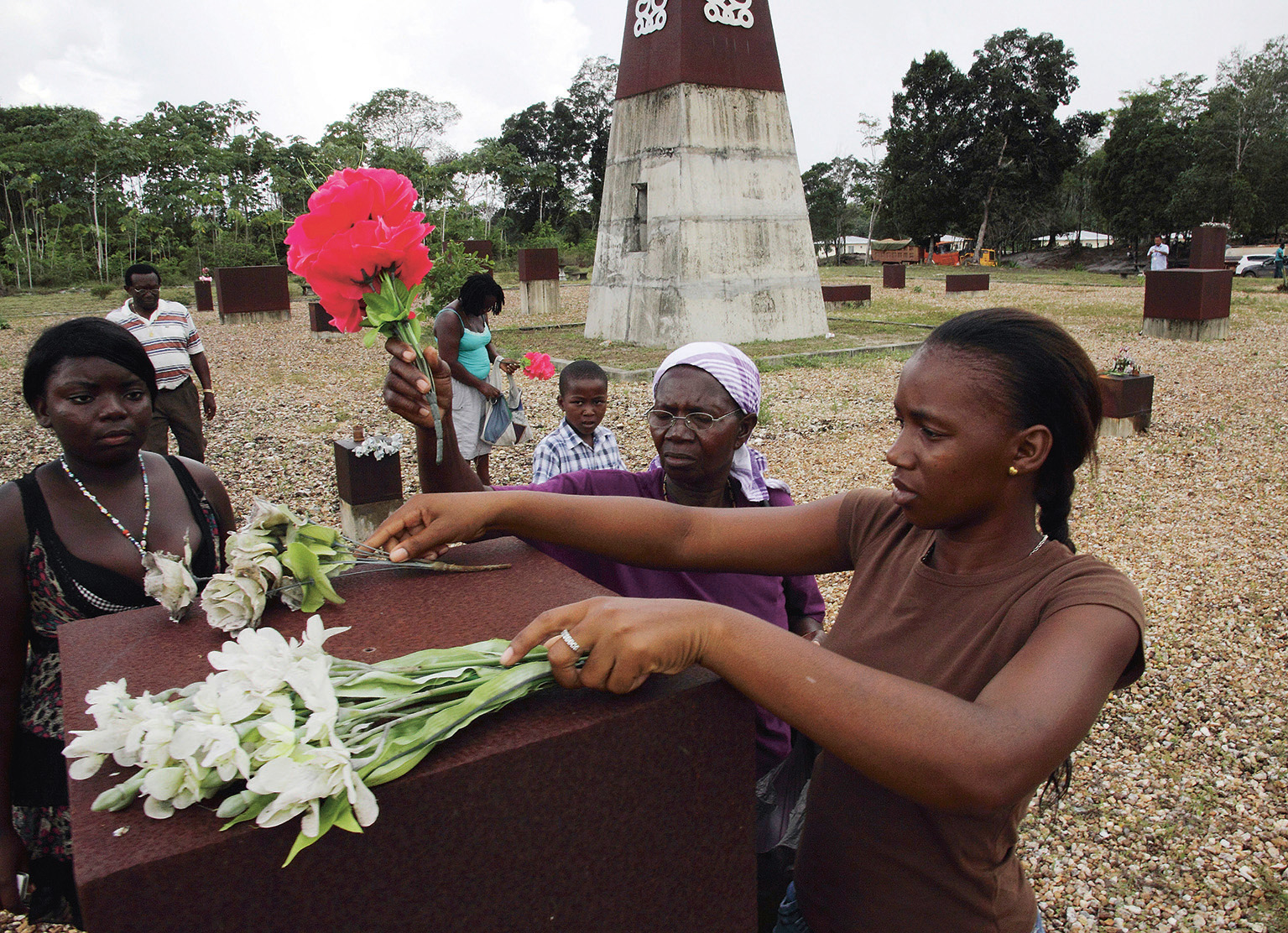 Marrons leggen bloemen bij een monument ter nagedachtenis aan het bloedbad in Moiwana.