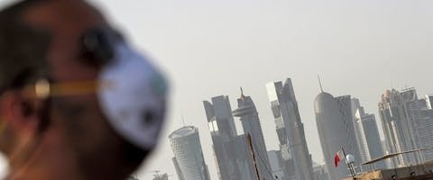 Een man, met een mondkapje om zich te beschermen tegen het coronavirus, in Doha, de hoofdstad van Qatar.