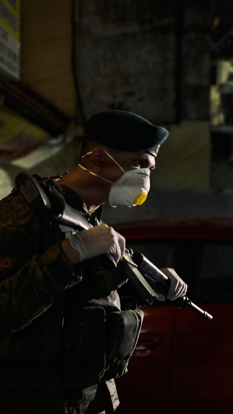 Een Filipijnse militair controleert mensen op straat tijdens een lockdown vanwege het coronavirus.