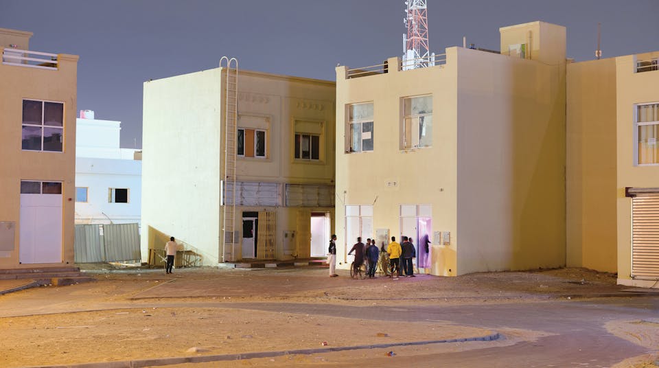 Arbeiders staan in de rij voor een illegaal bordeel in Dubai. De mannen zijn vaak jarenlang gescheiden van hun gezinnen, die niet mogen overkomen vanuit hun thuisland.