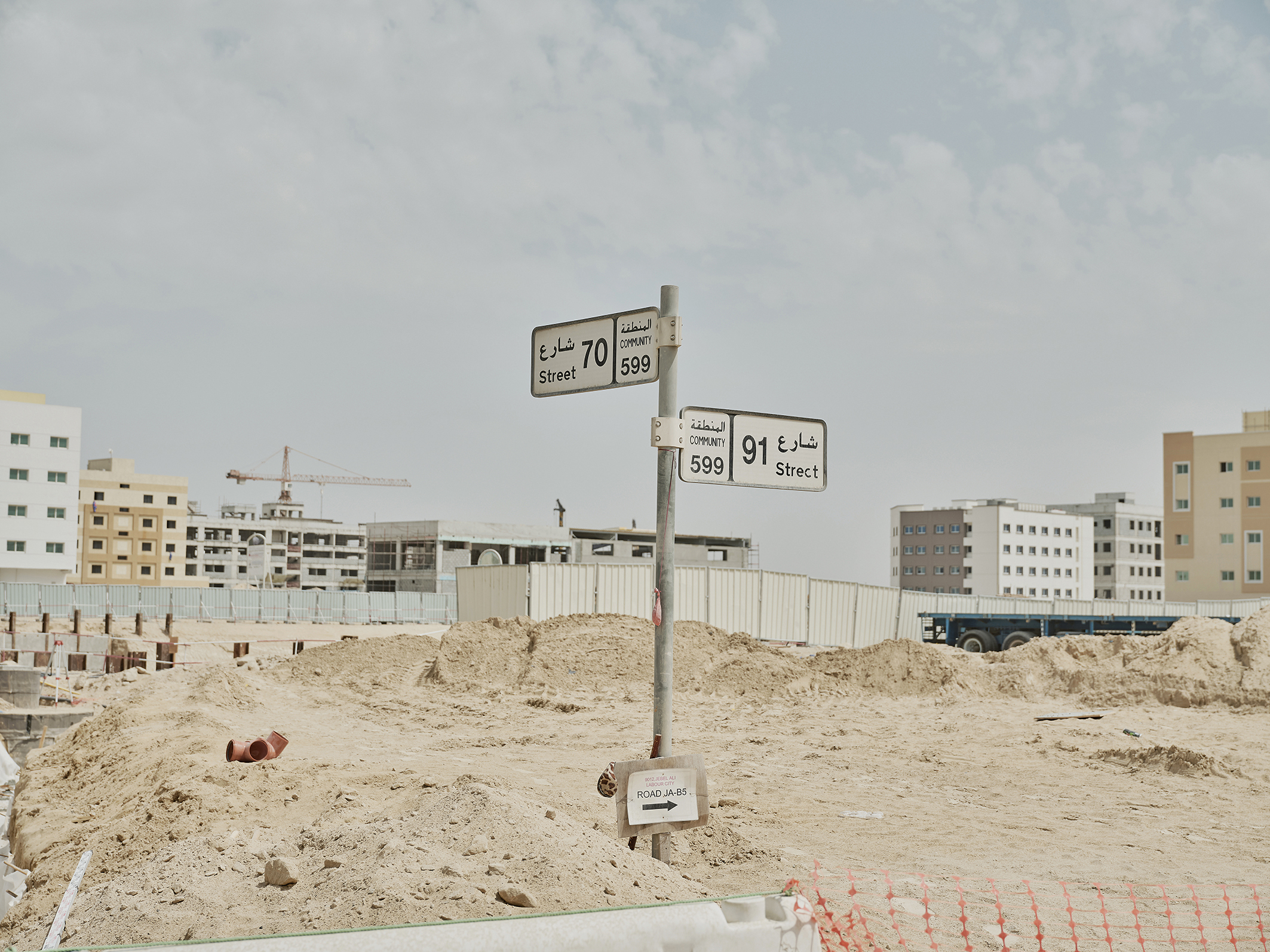 Op deze zandvlakte in Dubai moet een nieuwe wijk verrijzen. Het straatnaambord is alvast geplaatst.