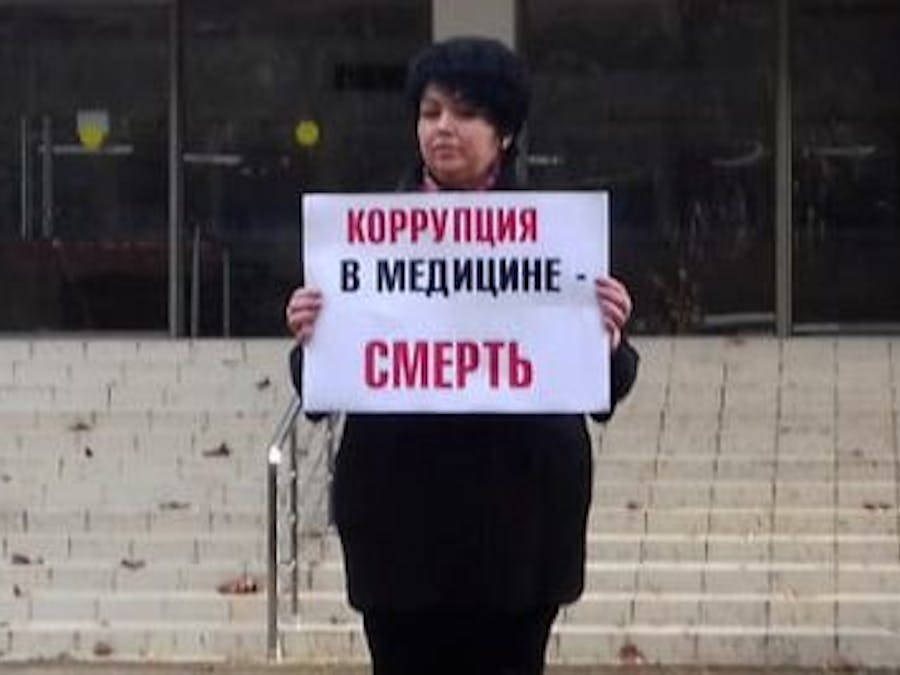 De Russische arts Yulia Volkova kan een fikse boete krijgen omdat ze kritiek uitte op de corona-aanpak in haar land. Op het bord staat: corruptie in geneeskunde = de dood.