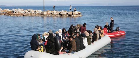 Een reddingsboot leidt migranten naar de haven van Thermi op Lesbos. Daar proberen inwoners ze tegen te houden.