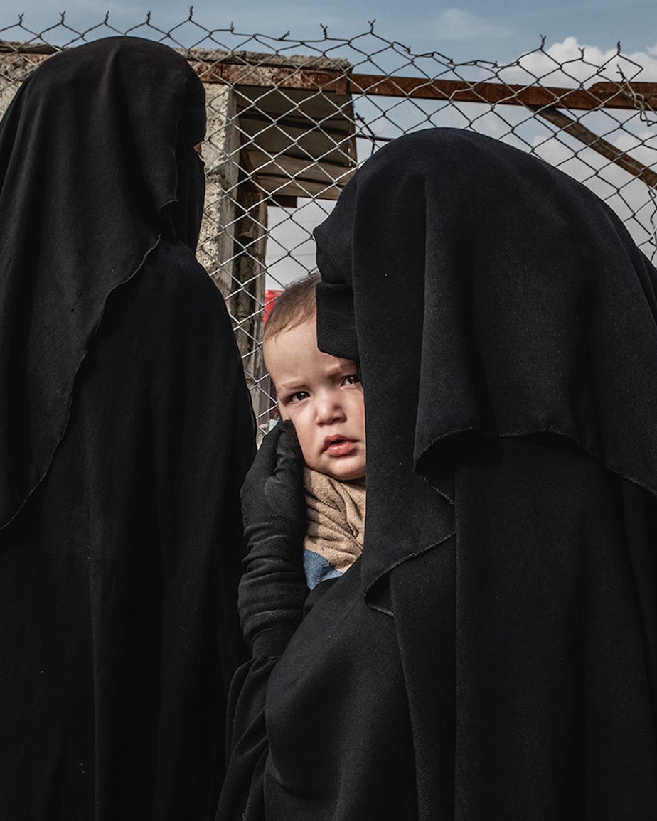 Een Russische IS-vrouw staat met haar kind in de rij voor medische hulp in het Al Hol-kamp in Noordoost-Syrië. Tot nu toe is er nog geen corona vastgesteld in het kamp.