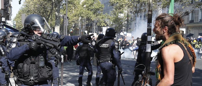 Een klimaatdemonstrant staat tegenover oproerpolitie tijdens een protest in september 2019 in Parijs.