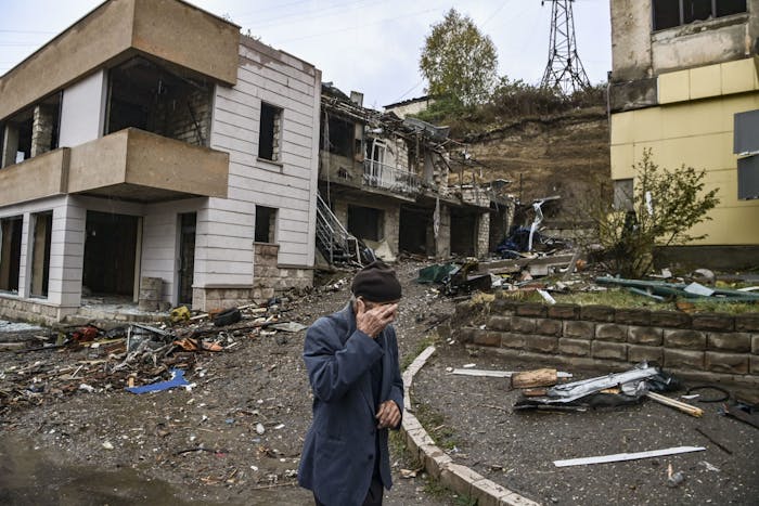 Een oude man loopt langs vernielde gebouwen in de hoofdstad nam Nagorno-Karabach. Armenië en Azerbeidzjan vechten om deze enclave, 6 oktober 2020